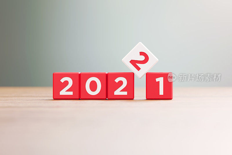 “2021”和“2022”书写的红色木块坐在前木表面散焦背景