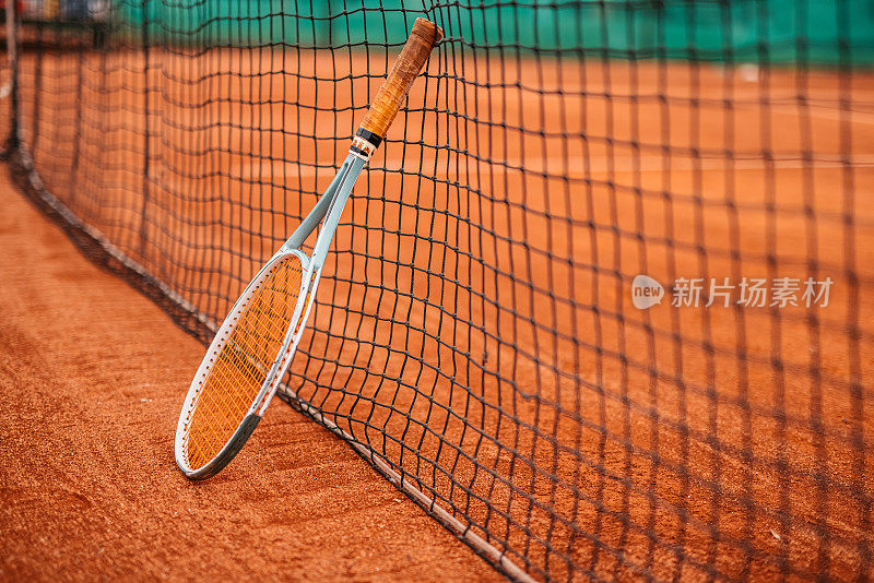 网球拍靠在球场的网上