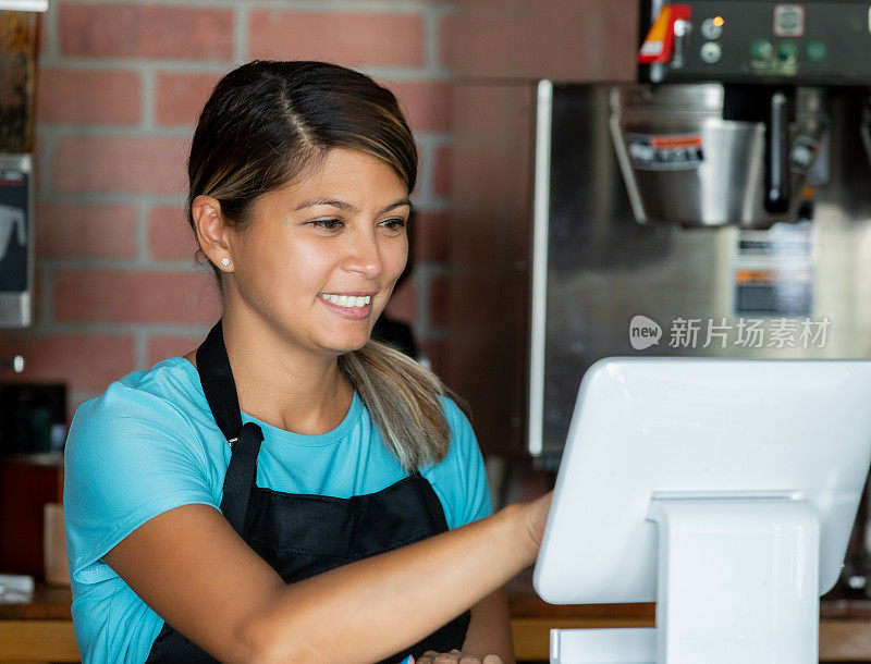 在当地咖啡店收银台工作的成年妇女