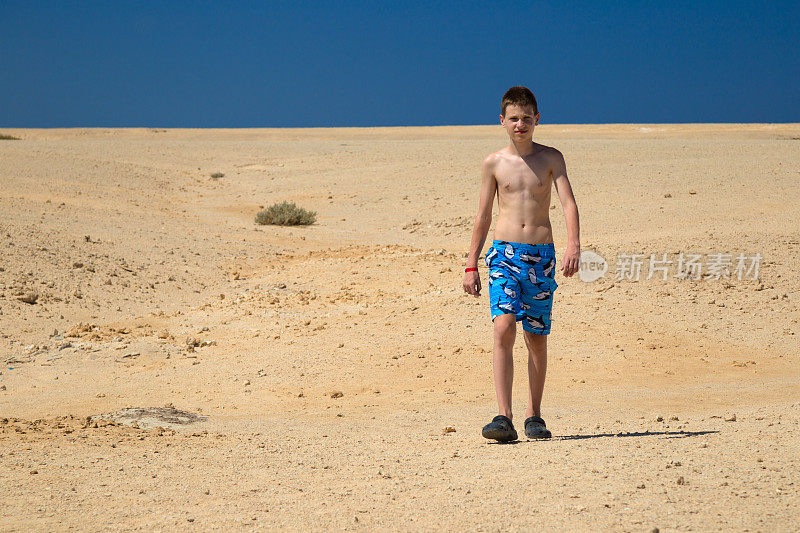 男孩在沙漠中行走