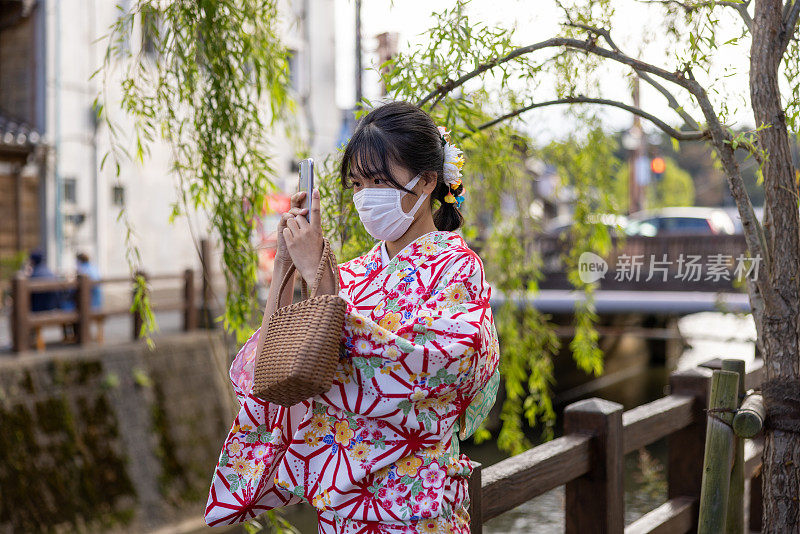 穿着和服的少女在日本村庄拍照