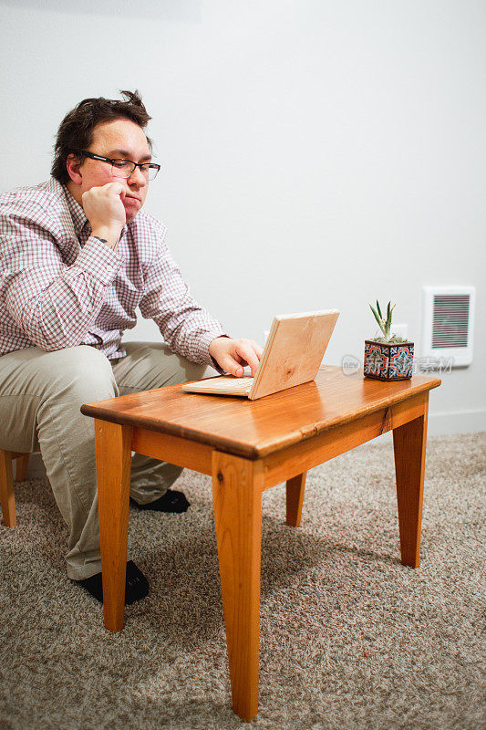 使用木制小桌子和木制笔记本电脑的书呆子办公室职员