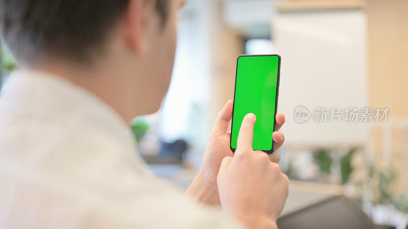年轻人使用绿色色度屏幕的智能手机