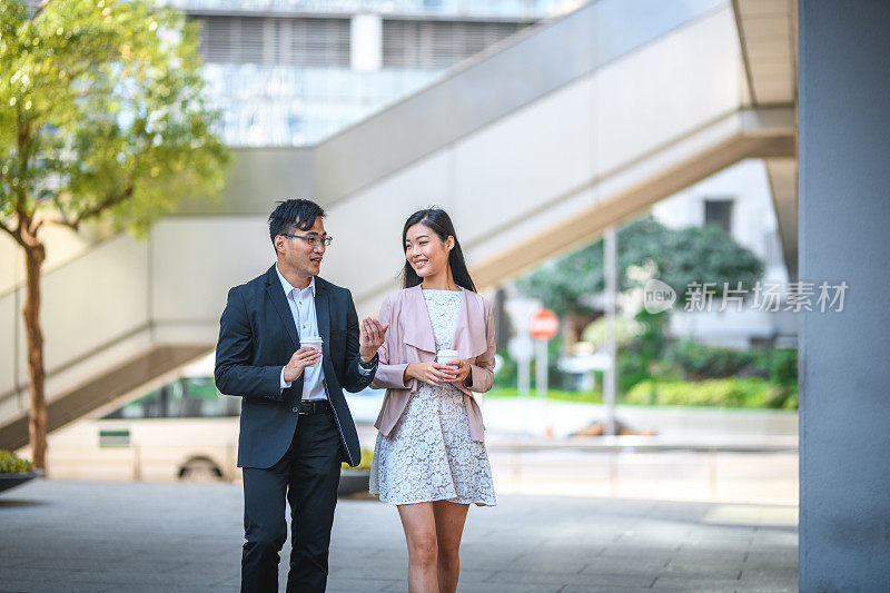 两个年轻的亚洲商业人士一起在户外散步