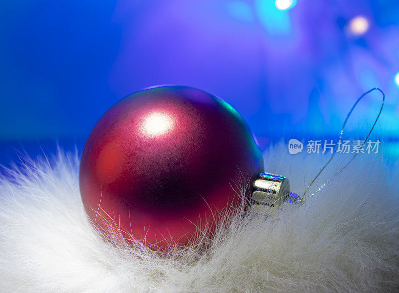 红色球圣诞装饰上的蓝色背景。圣诞节灯泡。