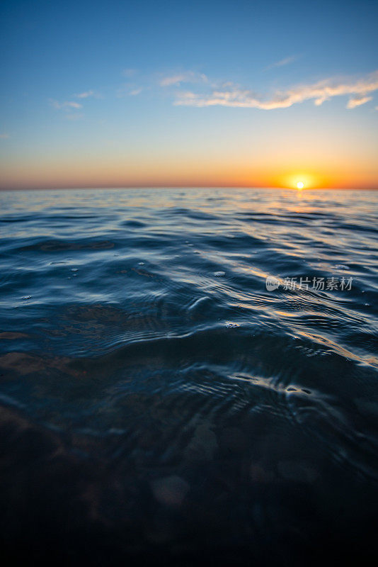 海上的夕阳和地平线上耀眼的太阳