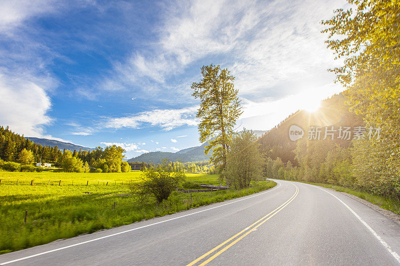 阳光灿烂的快乐道路旅行场景，蓝天碧草的开阔道路