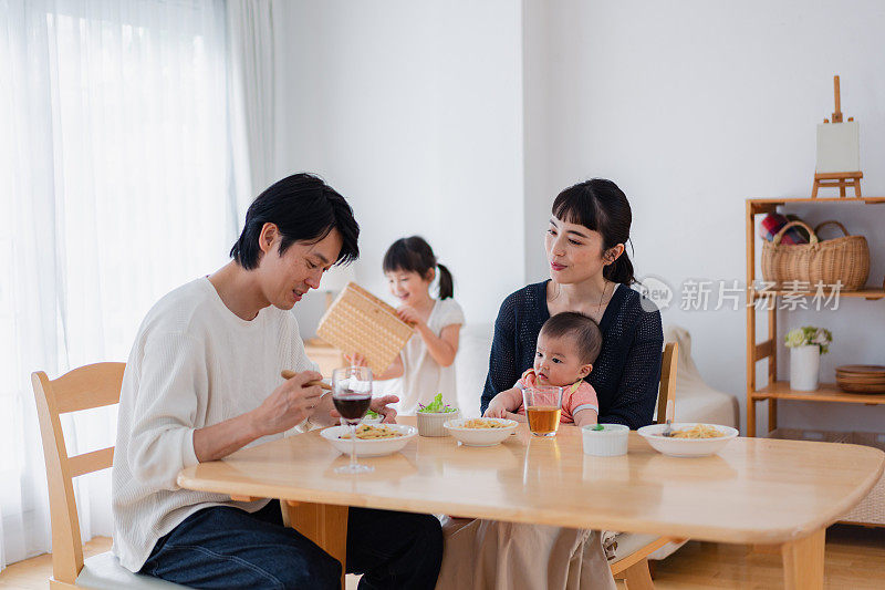 一家人带着孩子围坐在餐桌旁