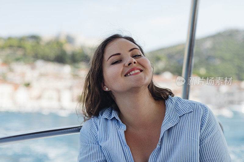 地中海的游船之旅:一个美丽的大码女人在船上的肖像