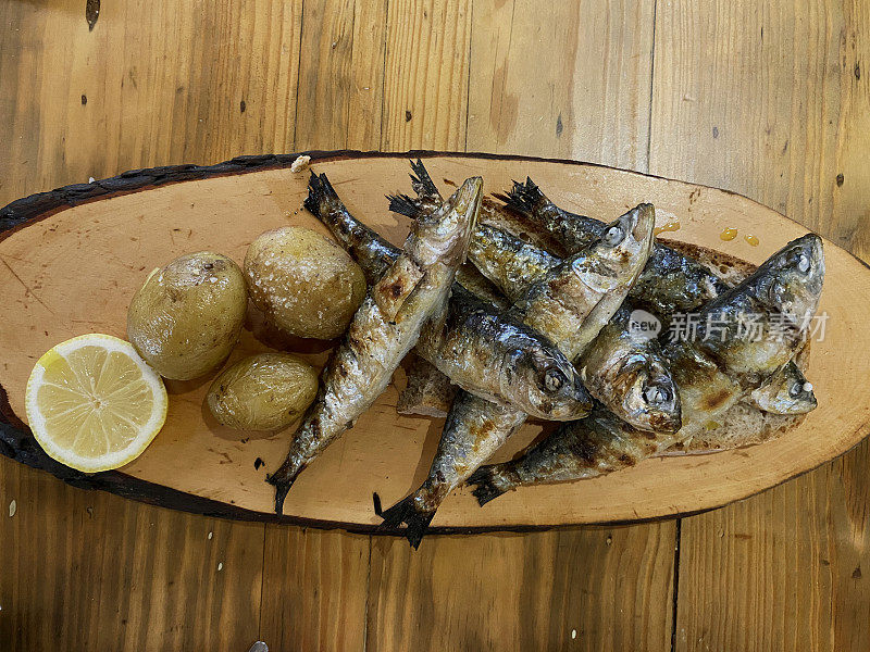 炭烤沙丁鱼配柠檬和烤土豆，是葡萄牙海岸典型的海鲜开胃菜。类似于西班牙的马拉加