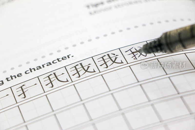 学习中文概念，学习简体字，笔在天子格纸上，练习用中文写“我”或“我”