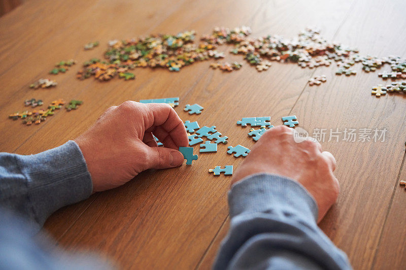 身份不明的男性在餐桌上玩拼图