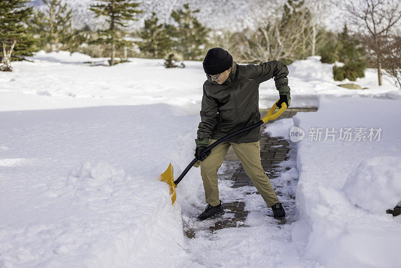 男孩在家里铲雪