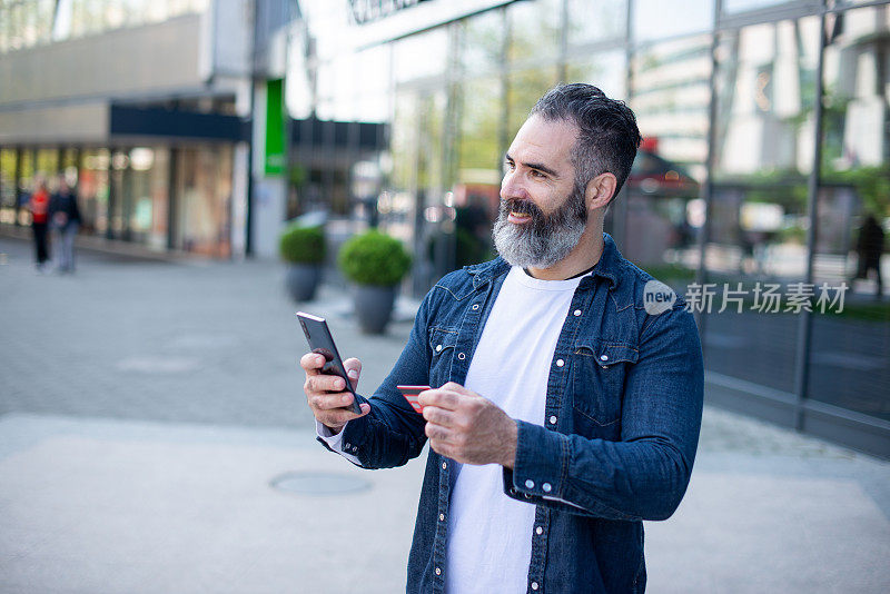 英俊的中年男子在城市里度假购物