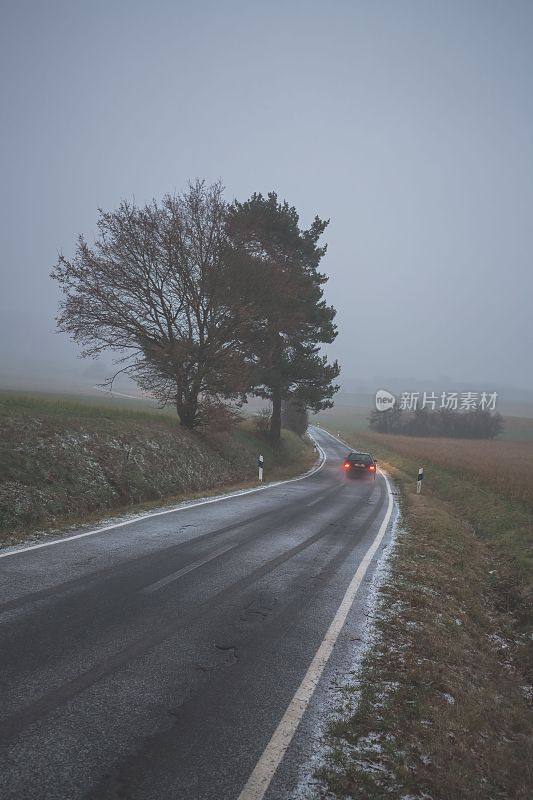 垂直拍摄的汽车在高速公路旁的树在一个雾蒙蒙的阴沉天气
