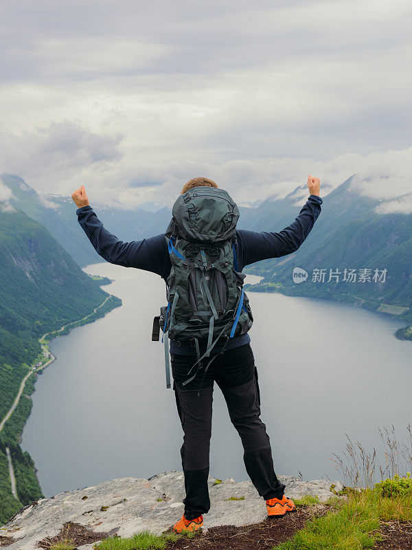 快乐人登上山顶，俯瞰挪威的自然风光