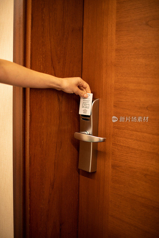一名女子用钥匙卡打开酒店房门