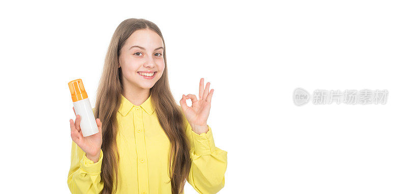 快乐的孩子呈现洗发水护发素瓶显示ok的手势孤立在白色的拷贝空间，广告。