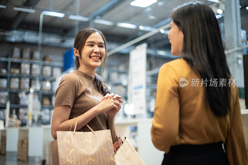 两个亚洲女孩在购物中心购物时和你聊天