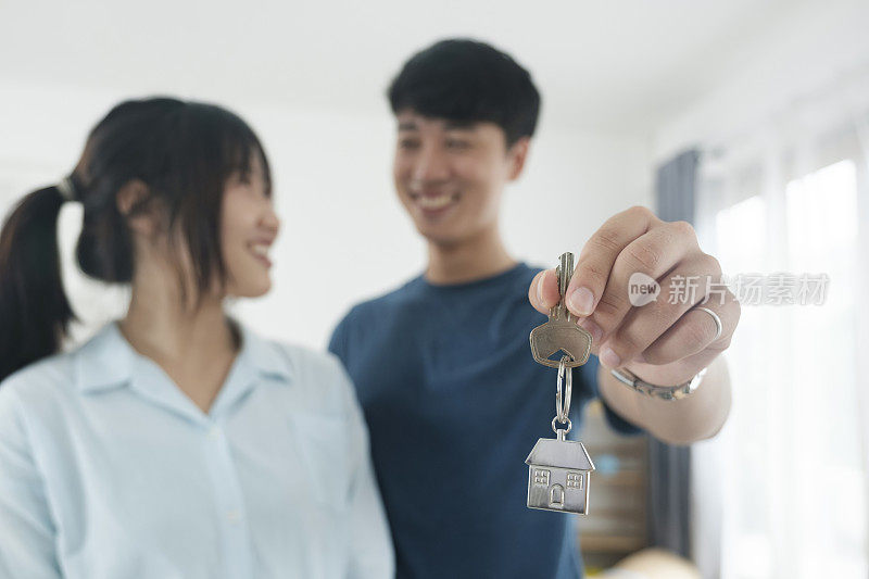 幸福的年轻夫妇买了新房子，收到了钥匙。