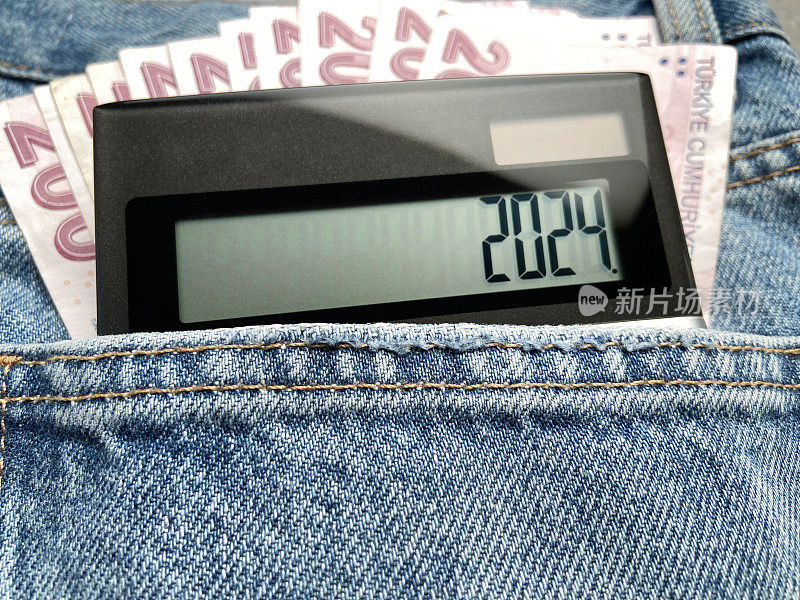 新年财经概念。口袋里的计算器显示印有2024字样的土耳其里拉纸币