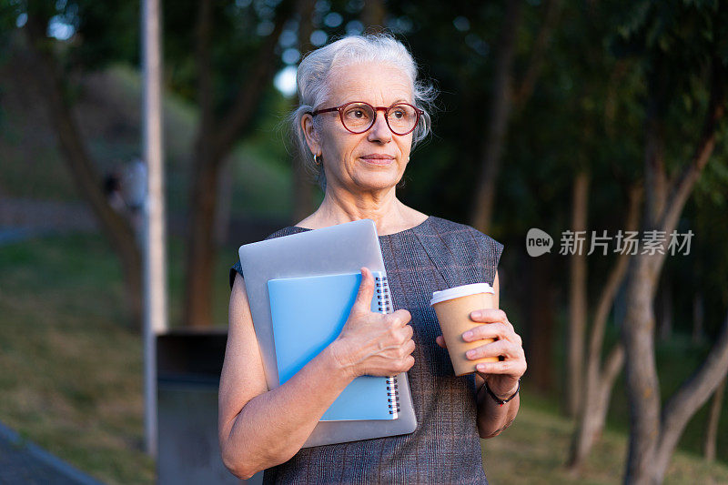 西班牙资深商务女士的肖像，灰白头发，复古眼镜，喝着咖啡。老太太拿着笔记本，蓝色笔记本和咖啡杯