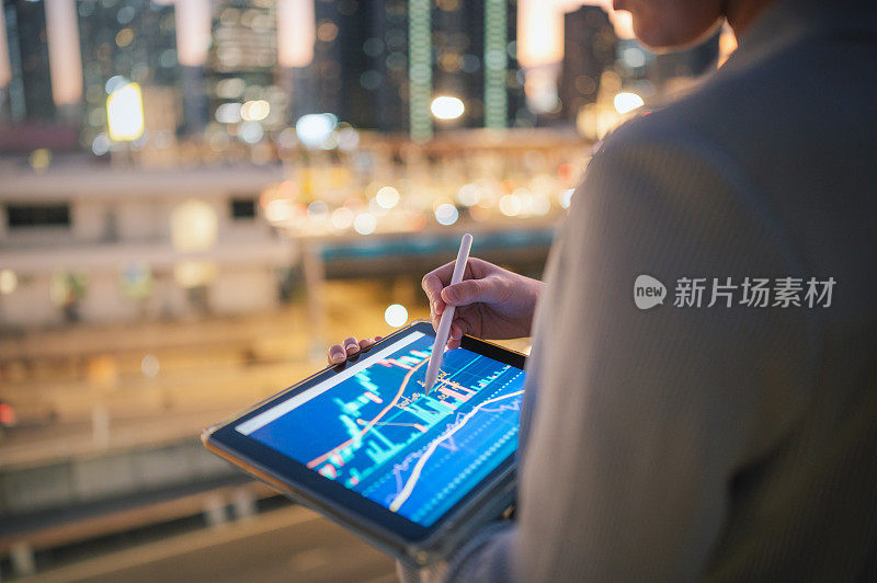 亚洲现代商人在她的平板电脑上查阅投资业绩跟踪表格和图表