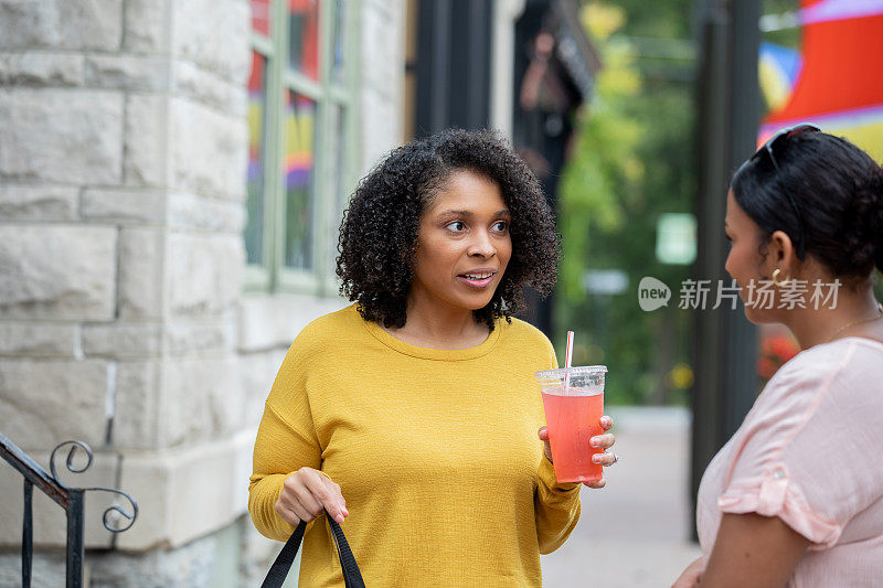 一个女人在女儿或朋友的陪伴下，在一个古色古香的小镇上享受购物的一天