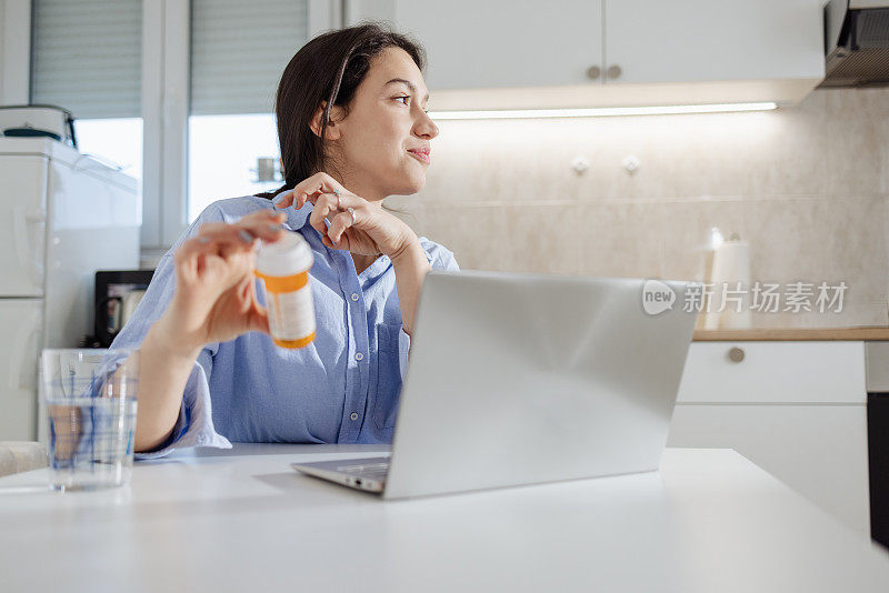 年轻女子在家里手里拿着一瓶药