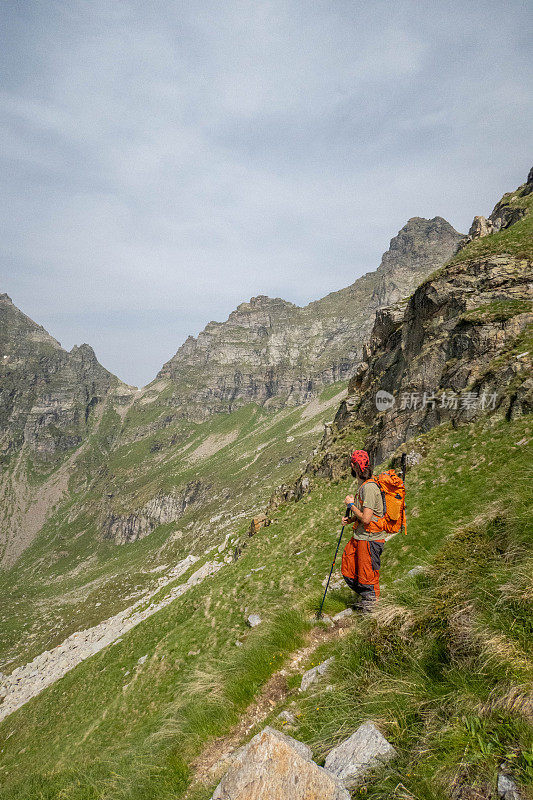 登山运动员在徒步旅行路线上的“夏季攀登:登山运动员沿着风景秀丽的徒步旅行”