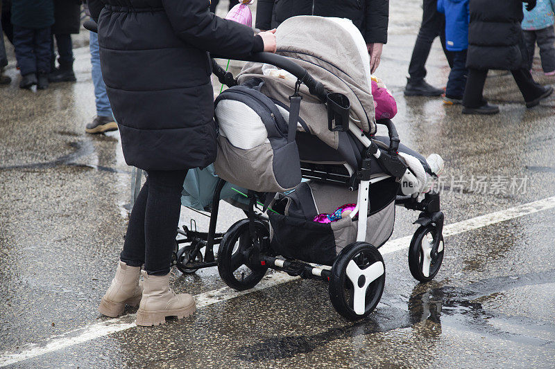 一位年轻的母亲和一辆婴儿车。