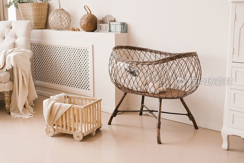 儿童房内部为婴儿准备的儿童柳条床，采用斯堪的纳维亚风格的浅米色调