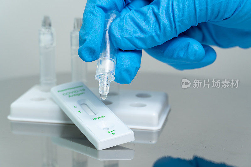 人将标本检测液滴入快速检测盒中检测冠状病毒Covid-19。家用个人抗原快速自检试剂盒。仅用于体外诊断。