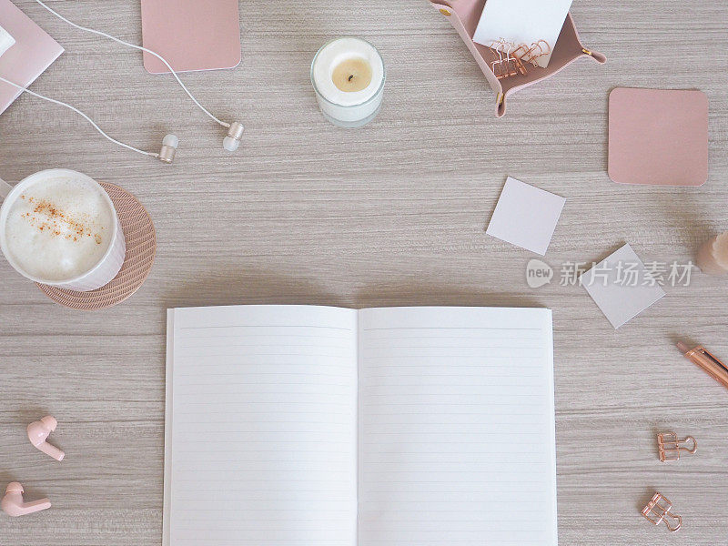 一张女性化的柔软办公桌的俯视图，基于浅木纹和粉色米色，一个女性化的工作空间的形象。
