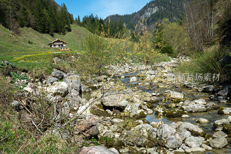 特罗肯巴赫，一条蜿蜒流经岩石河床的山间溪流。山景与草地和农舍