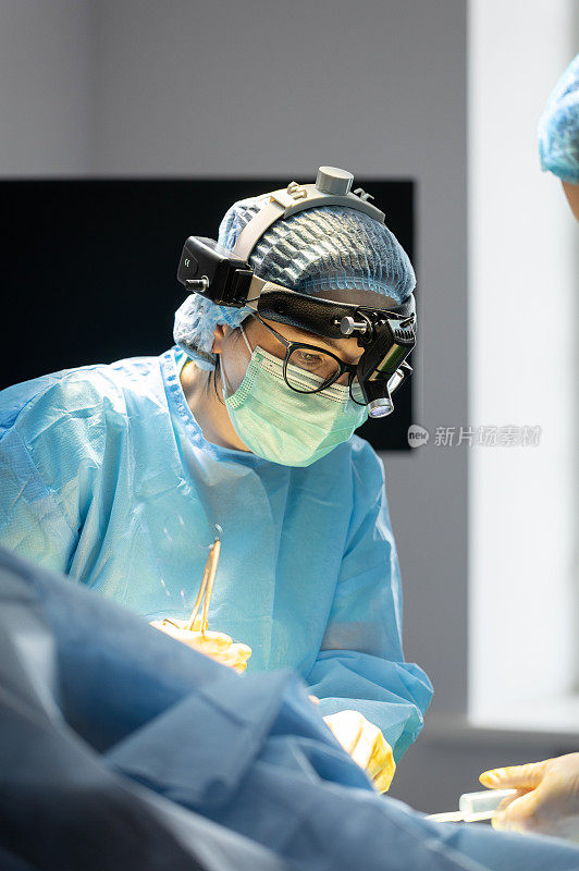 整形外科医生在妇女的乳房上做手术。