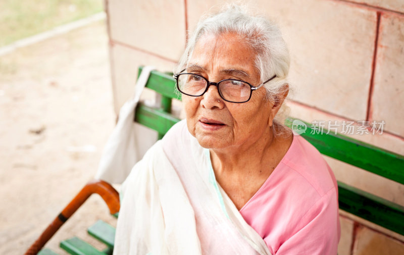 一位悲伤沉思的印度老妇人坐在户外