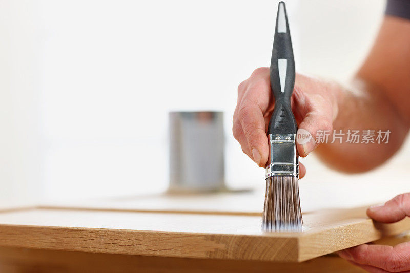 木匠在木板上涂清漆的手