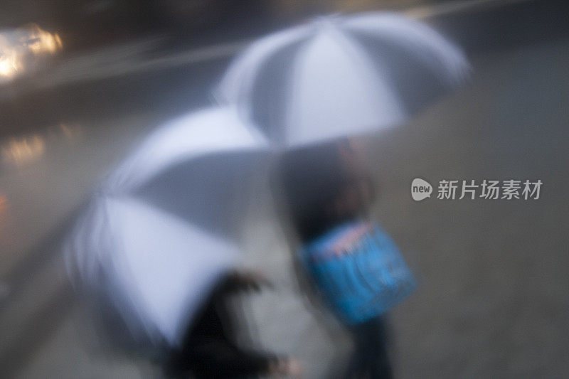 俯视雨天购物者的雨伞。