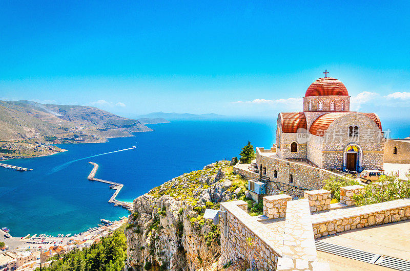 希腊悬崖上遥远的红色屋顶教堂