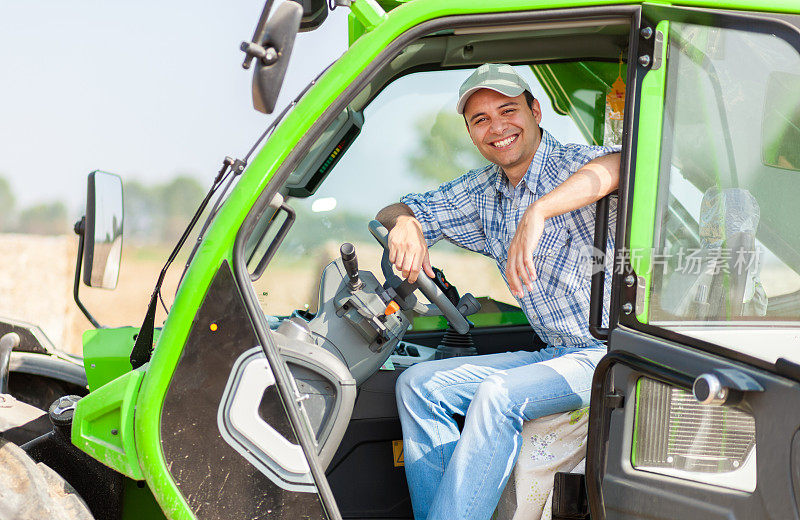 一个微笑的农民在他的拖拉机上的肖像