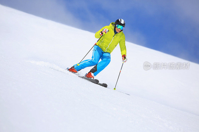 男子滑雪者在阳光明媚的滑雪胜地滑雪冬季运动