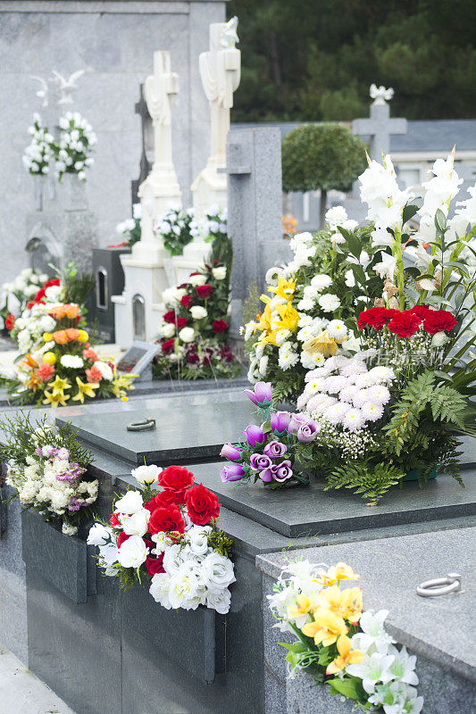 近距离的十字架，墓碑和鲜花在墓地。