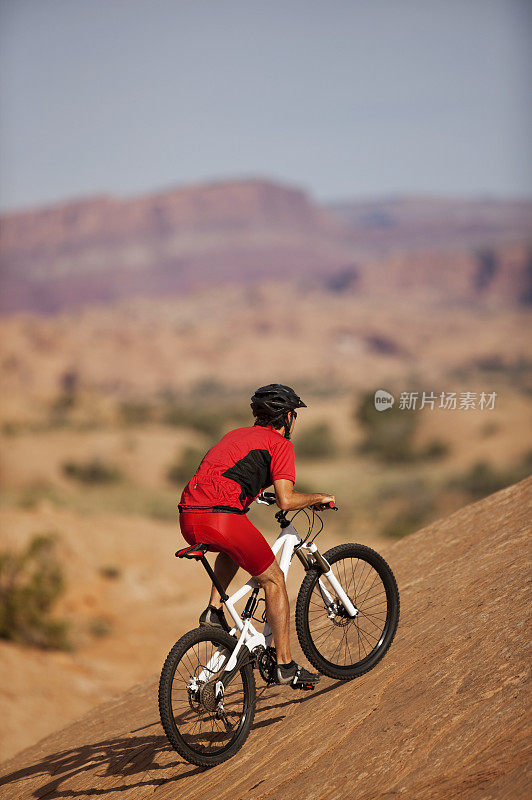 骑自行车的人骑在陡峭的山坡上滑石小径
