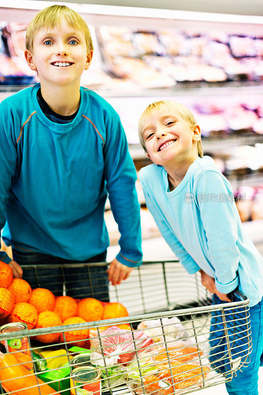 快乐的弟弟和妹妹在超市里推着购物车