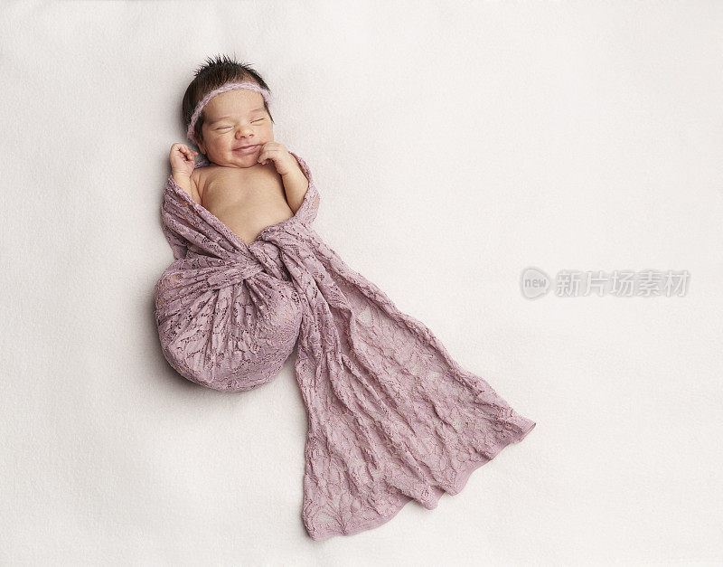刚出生的女婴在睡梦中微笑