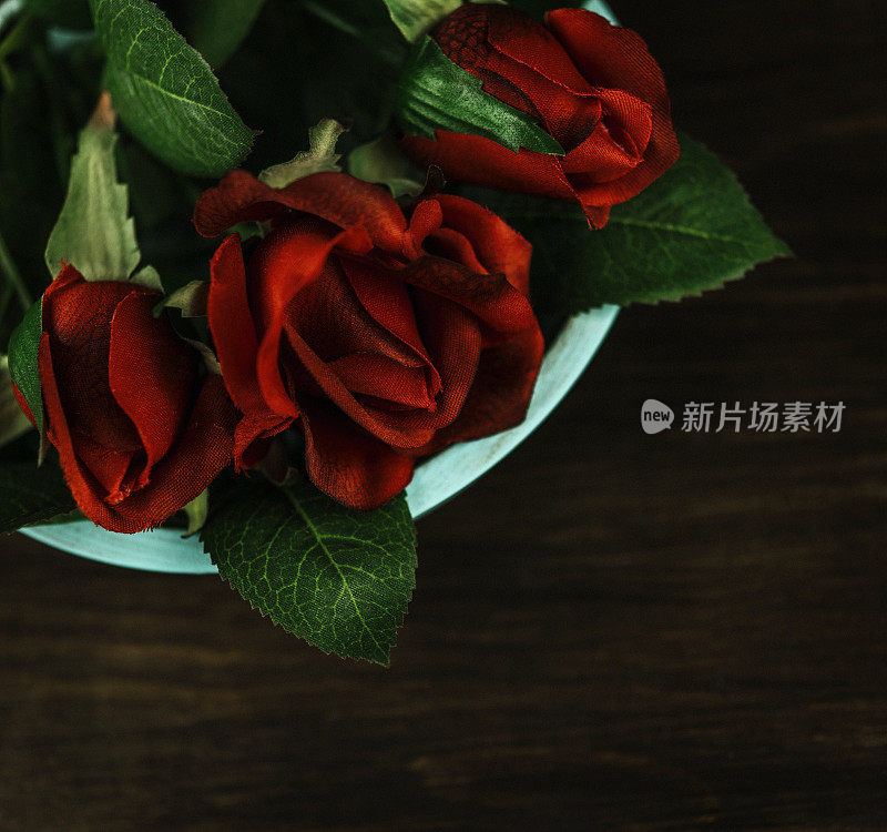 情人节的红玫瑰花束放在木蓝绿色的碗里