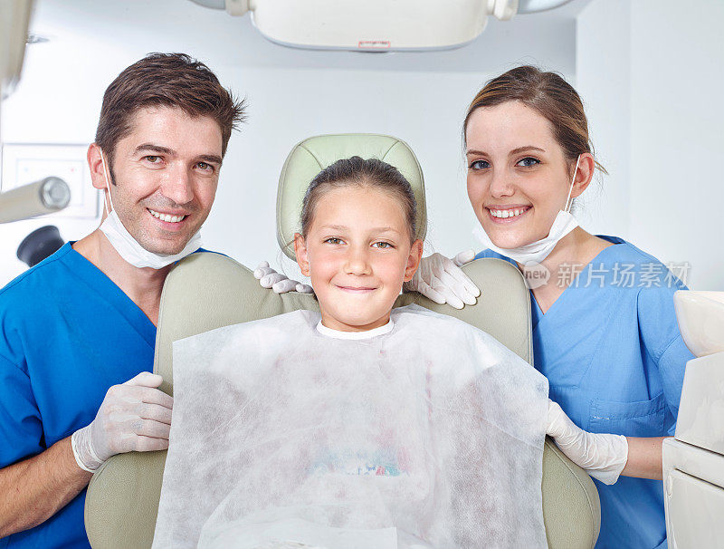 牙医，助理和女孩对着镜头微笑
