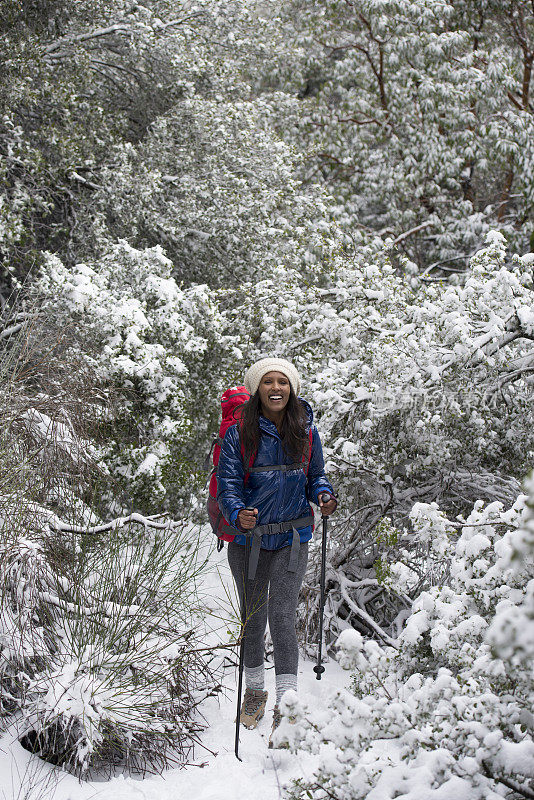 女人在下雪的天气徒步旅行。