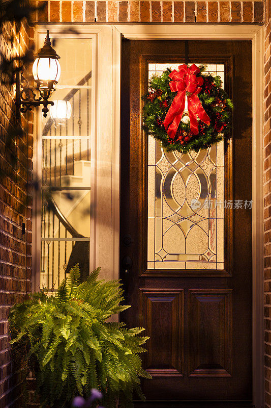 圣诞节:晚上挂在家门口的节日花环。